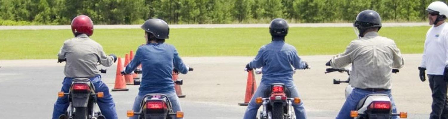 Several people on motorcycles at a training course.