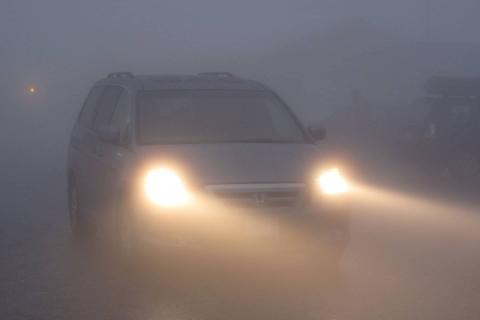 car driving in fog with lights on