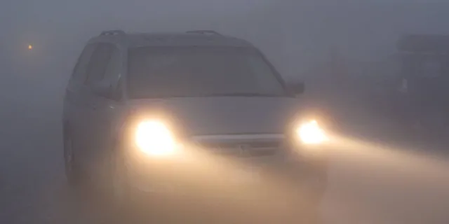 car driving in fog with lights on